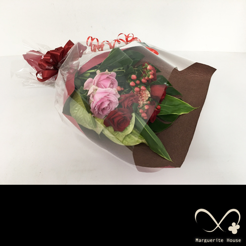 誕生日プレゼントで贈られた深みのある赤バラ中心の豪華な花束